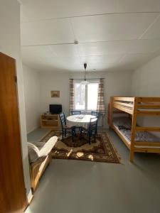 Zimmer mit einem Tisch und 2 Etagenbetten in der Unterkunft Huoneisto Äkäsjokisuu - Lapin Linna in Äkäsjoensuu