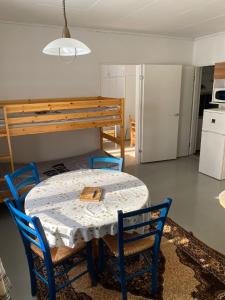 Cette chambre comprend une table, des chaises et un lit. dans l'établissement Huoneisto Äkäsjokisuu - Lapin Linna, à Äkäsjoensuu