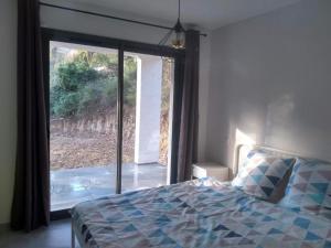 Un dormitorio con una cama y una ventana grande en Casa Vilallonga, en Villelongue-dels-Monts