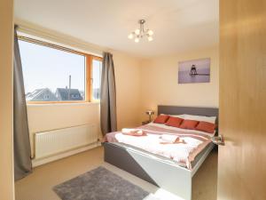 a bedroom with a bed and a large window at Flat 19 By The Beach in Harwich