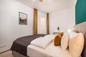 um quarto com uma grande cama branca com almofadas em Vagabond Grand'Or em Budapeste