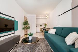 a living room with a blue couch and a table at Vagabond Grand'Or in Budapest