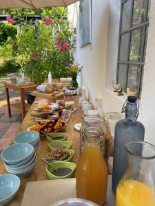 einen Tisch mit Teller mit Lebensmitteln und einer Flasche Orangensaft in der Unterkunft Østergård Kultur B&B in Læsø