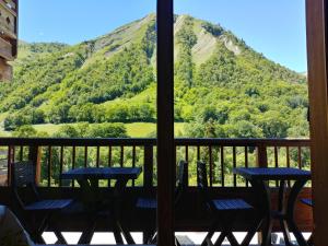 een veranda met tafels en stoelen en uitzicht op een berg bij Duplex avec piscine - Les Chalets de Saint Sorlin in Saint-Sorlin-dʼArves