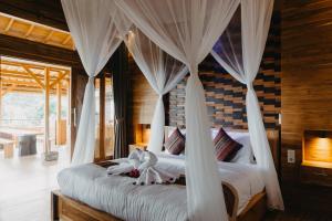 a bedroom with a bed with white drapes at Villa Bukit Sing Sing in Singaraja