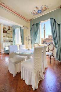 um quarto com uma mesa e cadeiras e uma torre do relógio em Palazzo Lenzi em Siena