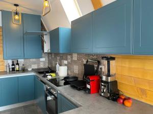 a kitchen with blue cabinets and a blender on a counter at Marisel Escape Cabin in Mărişel +18 photos