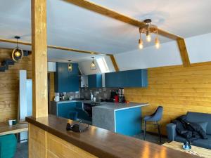 a kitchen with blue cabinets and a table and chairs at Marisel Escape Cabin in Mărişel