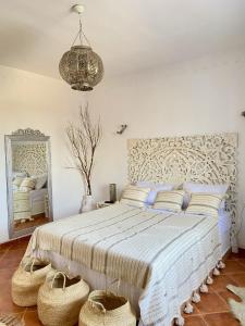 Villa Calma - Vue Mer في Al Ḩaddādah: غرفة نوم بسرير كبير مع سلال على الأرض