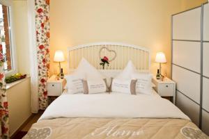 a bedroom with a bed with white sheets and pillows at Ostseeperlen-Haus 1 in Kühlungsborn