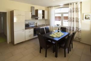 a kitchen with a black table and chairs and a kitchen with a kitchen at Ostseeperlen-Haus 1 in Kühlungsborn