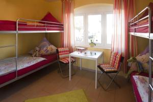 a room with bunk beds with a desk and a table at Ostseeperlen-Haus 1 in Kühlungsborn
