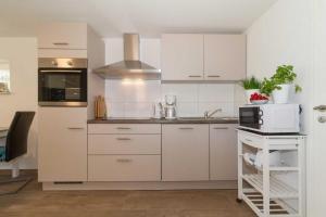 een keuken met witte kasten en een magnetron bij Ostseeperlen-Haus 2 in Kühlungsborn