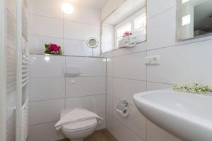 een witte badkamer met een toilet en een wastafel bij Ostseeperlen-Haus 2 in Kühlungsborn