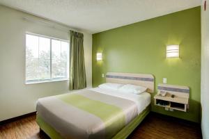 a bedroom with a large bed with a green wall at Super 8 by Wyndham Aurora East in Aurora