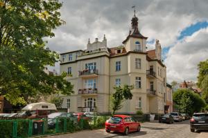 ソポトにあるImperial Apartments Helskaの建物前に停車する小型赤車