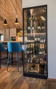 a bar with a blue chair and a shelf with glasses at Chalet Ortles in San Valentino alla Muta