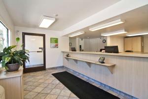 an office lobby with a reception counter and a potted plant at Motel 6-Roseville, MN - Minneapolis North in Roseville