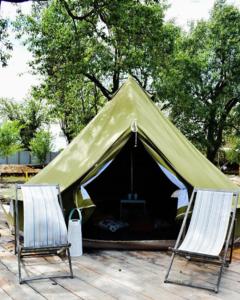 two chairs sitting in front of a green tent at BELLTENT SAVICA in Zagreb