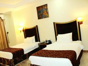 Un pat sau paturi într-o cameră la Tourist Hotel