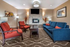 sala de estar con sofá azul y 2 sillas en Comfort Inn Joliet West I-80, en Joliet