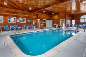 a swimming pool in a building with blue chairs at Comfort Inn Joliet West I-80 in Joliet