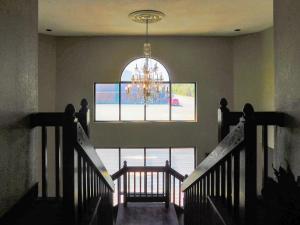 een trap met een groot raam en een kroonluchter bij Quality Inn & Suites Thomasville in Thomasville