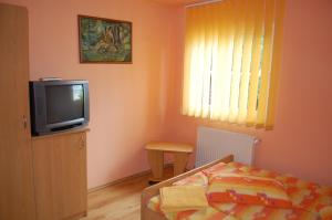 Habitación pequeña con TV y cama en Casa Kiss, en Sovata