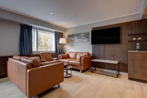 a living room with a couch and a flat screen tv at Radisson Blu Park Hotel, Oslo in Fornebu