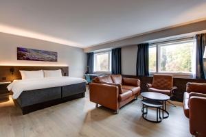 フォルネブにあるラディソン ブルー パーク ホテル オスロのベッド、ソファ、椅子が備わるホテルルームです。