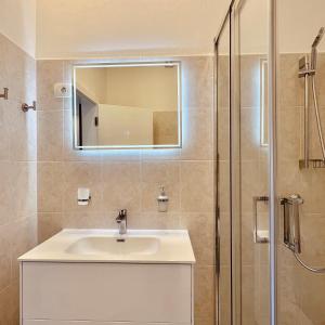 a bathroom with a sink and a shower at Zaro Apartments in Izola +23 photos