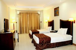 Un pat sau paturi într-o cameră la Tourist Hotel