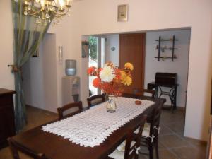 a dining room table with a vase of flowers on it at Bed&Breakfast L'Oasi in Nardò