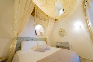 a bedroom with a white bed with a ceiling at Trullo Love in Alberobello