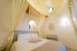 1 dormitorio con cama blanca y techo en Trullo Love, en Alberobello