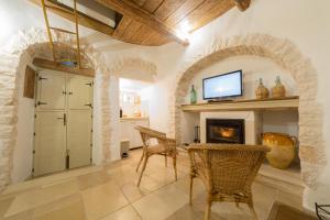 Una sala de estar con chimenea y televisión. en Trullo Love, en Alberobello 10 fotos más