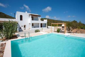 Villa con piscina frente a una casa en Villa Can Sunyer.Ibiza. en Ibiza