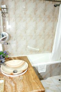 a bathroom with a wooden toilet on a counter next to a bath tub at Tourist Hotel in Doha