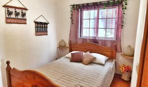 ein Schlafzimmer mit einem Holzbett mit Fenster in der Unterkunft Casa Branca Holiday Resort in Salir + 41 Fotos