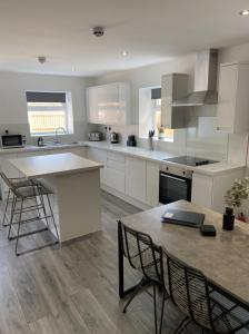 a kitchen with white cabinets and a table and chairs at Charles Alexander Short Stay - The Gateway in Blackpool