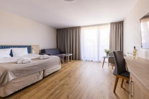 um quarto de hotel com uma cama grande e uma secretária em Maloves Resort & Spa Prywatne Apartamenty em Władysławowo