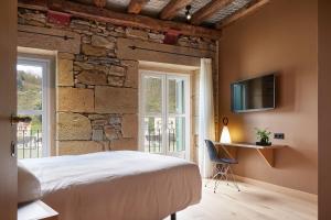 a bedroom with a bed and a tv on the wall at Donibanea in Pasajes de San Juan