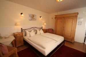 a bedroom with a large bed with white sheets and pillows at Hotel Pfälzer Hof in Lauterecken