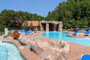 une grande piscine avec un mur de roche dans un complexe dans l'établissement White Oak Resort Southern Comfort, à Gatlinburg