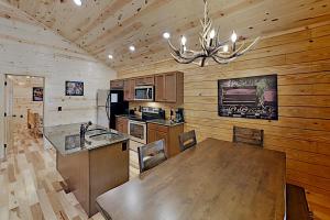 une cuisine avec une grande table en bois et un lustre dans l'établissement White Oak Resort Southern Comfort, à Gatlinburg