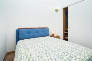 un letto con testiera blu in una camera da letto di TRE PINI a Procida
