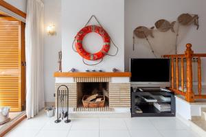 uma sala de estar com lareira e televisão em La marinera Beach House em Platja d'Aro