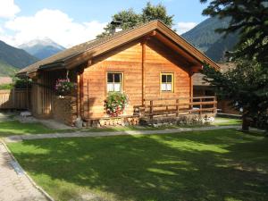 a log cabin with a green lawn in front of it at Ferienhaus Dummer in Flattach