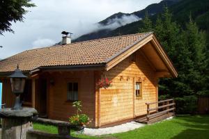 a small wooden cabin with a mountain in the background at Ferienhaus Dummer in Flattach
