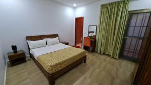a bedroom with a bed and a desk with a mirror at Oasis, Seaside in Dakar